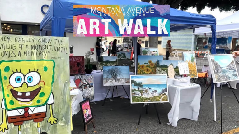 Outdoor art market booth with a colorful 'Art Walk' banner, displaying framed landscape paintings and a SpongeBob cutout on the left.