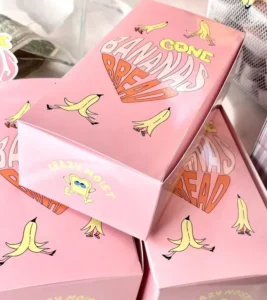Pink packaging boxes with cartoon bananas and bold yellow/orange text reading 'Gone Bananas' stacked together, banana-themed product packaging.