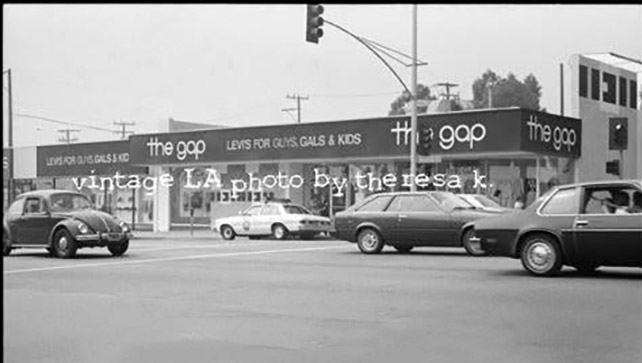 Black-and-white vintage Los Angeles street scene at a busy intersection with a Gap storefront; overlaid text reads 'vintage LA photo by Theresa K'.