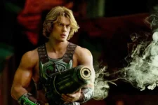 Muscular sci-fi warrior in armor holds a large futuristic weapon amid green-tinged steam or smoke in a dark environment.