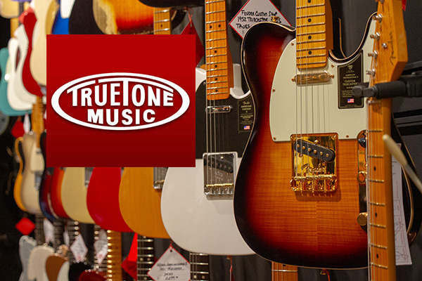 Guitars on display in a music shop; a red TrueTone Music logo overlays the foreground.